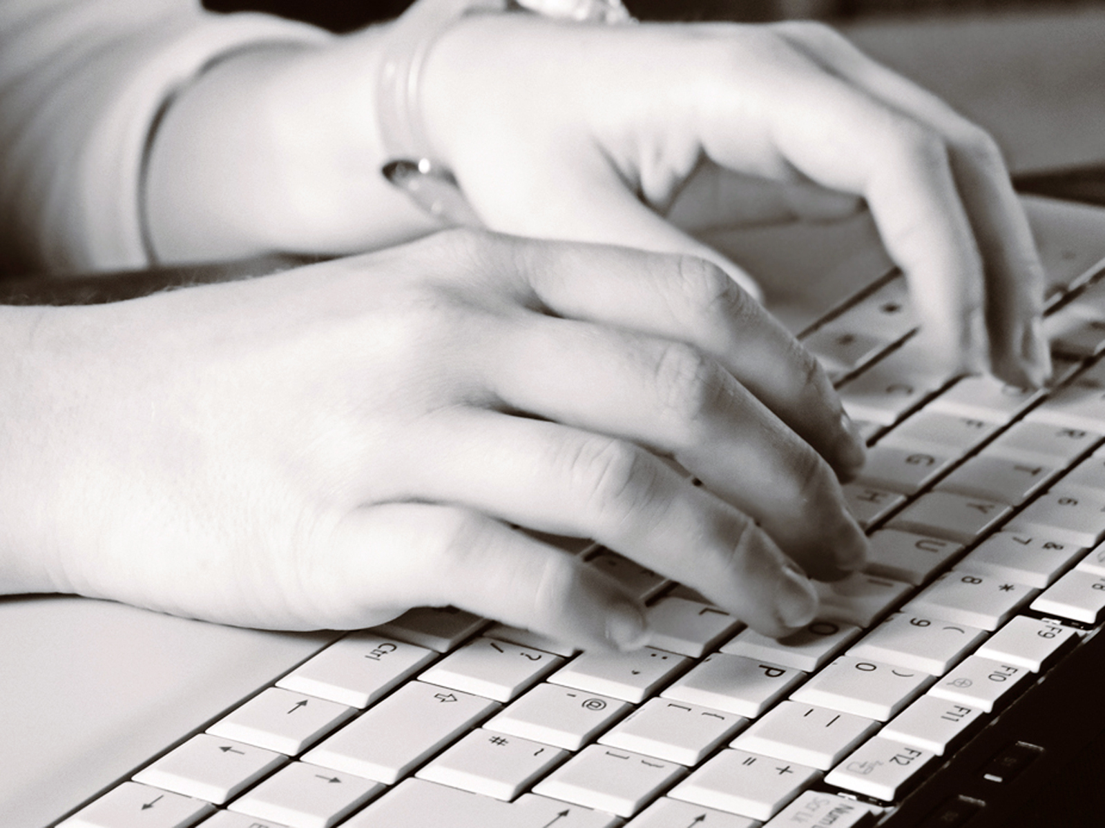 Hands typing on computer